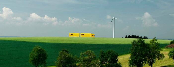 LKW in Landschaft mit Windrad