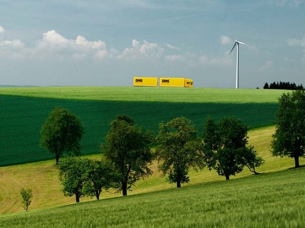 LKW in Landschaft mit Windrad